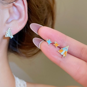 Vue détaillée des puces d'oreilles étoile et avion avec émail coloré bleu et orange vif