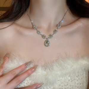 Detail of silver drop necklace featuring sparkling rhinestones and geometric crystal pendant