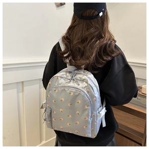 Rear view of a grey floral backpack featuring adjustable straps and nylon fabric