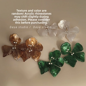 Detailed macro view of resin flower earrings with sparkling rhinestones and petal texture