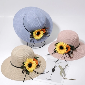 Detailed texture of woven straw hats featuring yellow sunflower decor and ribbon bows