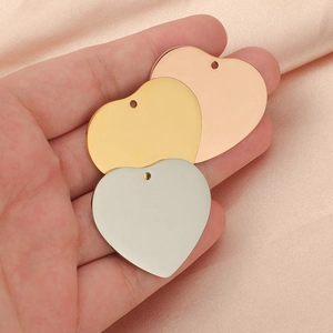 Polished stainless steel heart pendants in silver, gold and rose gold on a hand