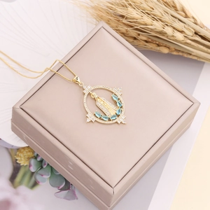 Gold Virgin Mary pendant necklace with micro-paved zircons and blue stones on jewelry box