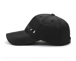 Side view of black quick-dry baseball cap with extended brim and decorative side logo