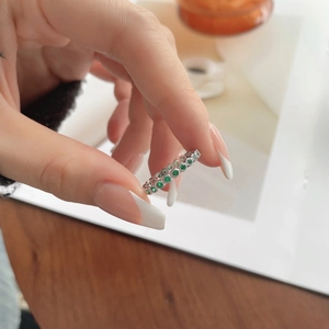Macro shot of S925 silver eternity ring with round emerald green cubic zirconia stones