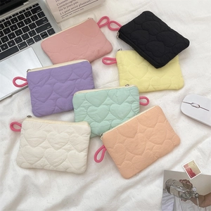 Detailed view of heart-quilted macaron mini storage bags in seven pastel colors