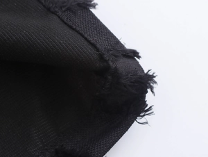 Detailed macro shot of black oversized double-breasted coat fabric with ribbing and raw edges