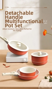 Orange non-stick cookware set with detachable handles on a modern wooden countertop