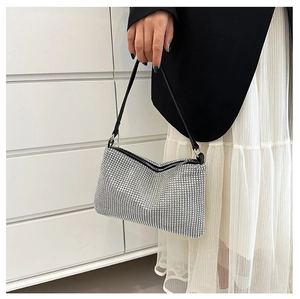 Detail of silver rhinestone crescent bag featuring leather strap and metal ring hardware