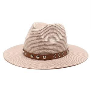 Close-up of beige straw cowboy hat featuring a brown leather band with silver metal studs