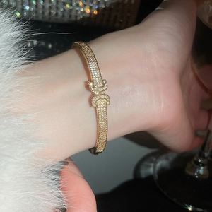 Vue macro du bracelet boucle fer à cheval doré orné de zircons cubiques scintillants