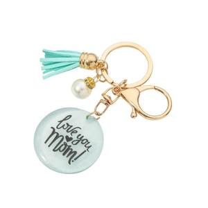 Porte-clés MOM en résine avec pompon turquoise et perle sur fond blanc éclatant