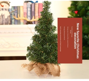 Close-up of a 20cm miniature Christmas tree with a rustic burlap base for holiday decor