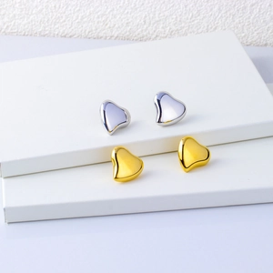 Minimalist 18K gold and silver heart-shaped stud earrings with polished metallic finish