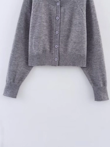 Detail view of medium grey knit cardigan featuring round neck and five matching buttons