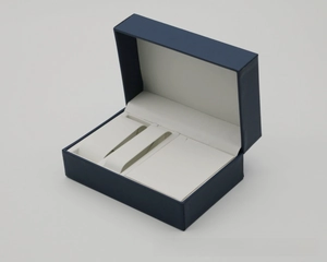 Detail view of navy blue PU leather jewelry box with multi-compartment white inner lining