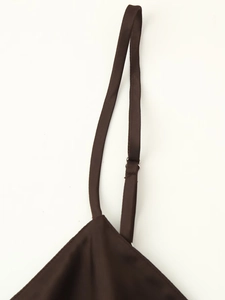 Close-up of adjustable strap and precise stitching on dark brown satin dress