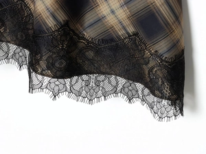 Gros plan sur un tissu à carreaux marron avec des détails de dentelle noire