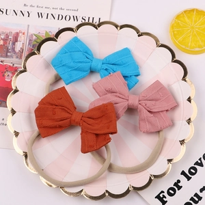 Detailed close-up of three soft ribbed cotton baby bow headbands in candy colors