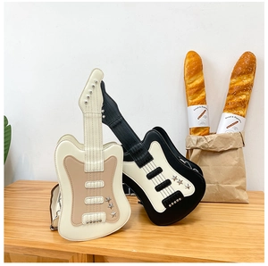 Detailed close-up of guitar-shaped crossbody bags in beige and black with metal studs