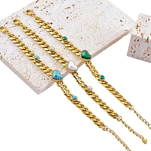 Golden Cuban link bracelet featuring heart and round turquoise and pearl charms