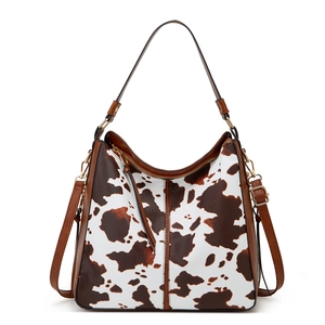 Detail of vintage brown cow print PU leather tote bag with dual straps and zipper closure