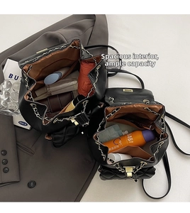 Detail view of the spacious brown interior and gold chain straps of a quilted backpack