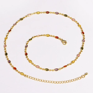 Macro shot of 18K gold plated necklace with colorful zircon gemstones on white background