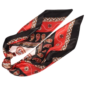 Detail of silk-satin scarf with red and black paisley pattern tied in a soft knot