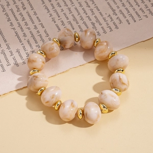 Detail of vintage acrylic oval beads with marble texture and golden spacers for necklace