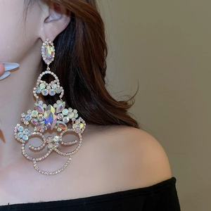 Gros plan de boucles d'oreilles fleurs dorées avec strass étincelants portées par un mannequin