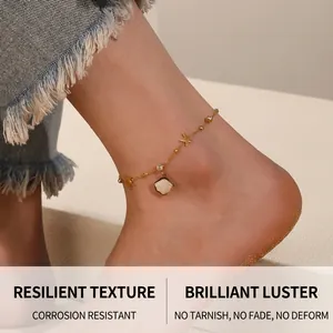 Detail of gold starfish and shell pendant anklet worn on beach with ocean wave background