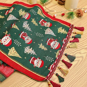 Detail of Christmas table runner with Santa Claus motif and colorful tassel accents