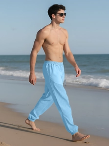 Detail of light blue linen trousers with drawstring waist and textured summer fabric