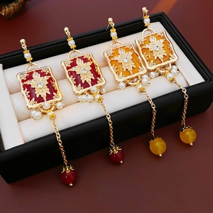 Detail of vintage flower square earrings with hanging artificial pearls and gold chains