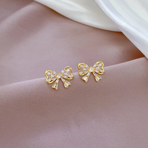 Detailed macro view of gold butterfly stud earrings with sparkling cubic zirconia inlay
