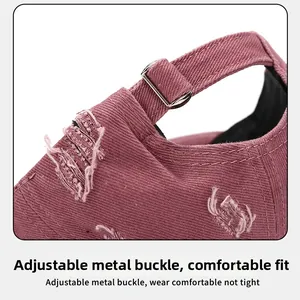 Close-up of adjustable silver buckle and distressed fabric texture on pink baseball cap