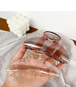 Close-up of translucent pink and smoke gray oversized acrylic hair claws for thick hair