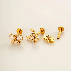 Golden butterfly and flower cartilage studs set with sparkling zircon in a macro view