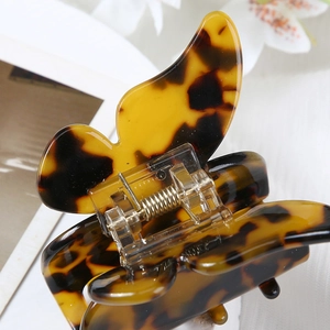 Close-up of butterfly hair claw clip with amber and dark brown tortoiseshell texture