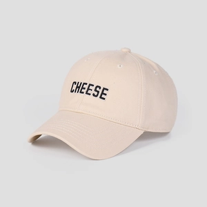 Detail der schwarzen CHEESE-Stickerei auf einer beigen Baseballkappe aus Baumwoll-Twill