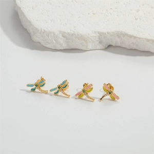 Macro detail of dragonfly stud earrings with enamel wings and sparkling zircon inlay