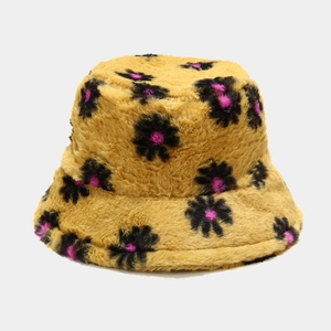 Detailed texture of yellow plush bucket hat with floral daisy patterns for winter