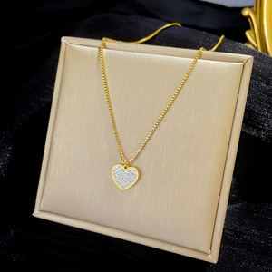 Close-up of heart pendant necklace with gold chain and pavé crystal details
