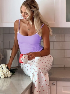 Détail du caraco violet et du pantalon imprimé cerises dans une cuisine cosy