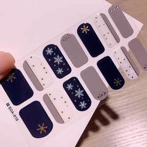 Détail de stickers à ongles de Noël avec flocons dorés et strass, modèle SDA-010