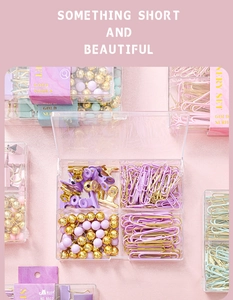 Detailed top view of purple and pink stationery set with gold clips and push pins