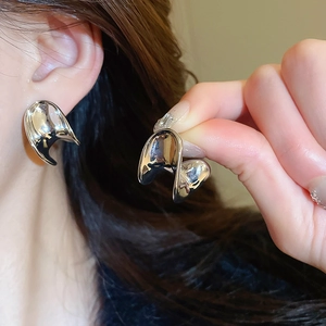 Detailed view of silver liquid metal C-shaped stud earrings with glossy fluid design
