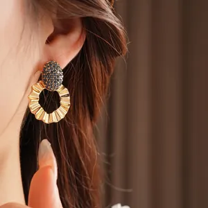 Minimalist gold wavy hoop earrings with navy pavé crystal stud on model close-up