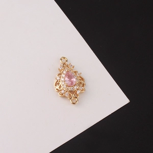 Vue macro du pendentif goutte dorée avec zircon rose et filigrane ajouré